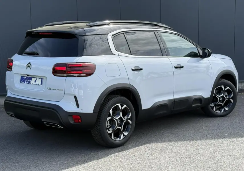 Vue 3/4 arrière droite du Citroën C5 Aircross blanc Okenite avec toit noir Perla Nera et jantes alliage bi-ton.