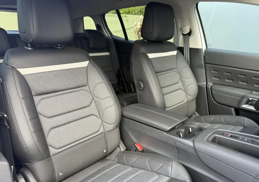 Vue intérieure côté droit des sièges avant gris foncé et tissu clair du Citroën C5 Aircross 2026 avec accoudoir central.