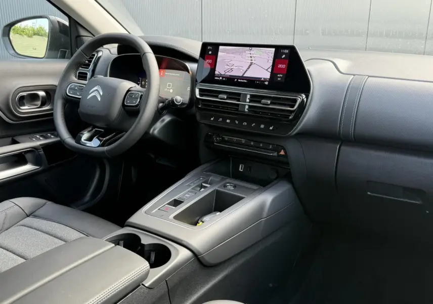 Vue intérieure côté conducteur du Citroën C5 Aircross 2026 avec tableau de bord noir et écran tactile central.
