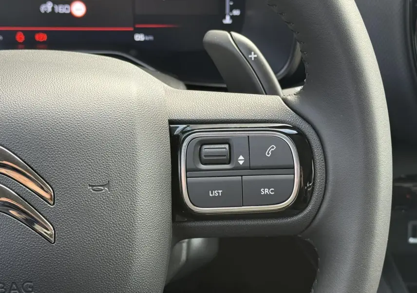 Gros plan sur les commandes à droite du volant noir du Citroën C5 Aircross 2026, avec palettes de changement de vitesse.