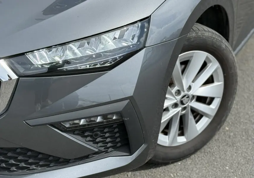 Gros plan sur l'avant droit gris graphite d'une Skoda Scala TSI 116 avec phare Full LED et jante alliage 16 pouces.