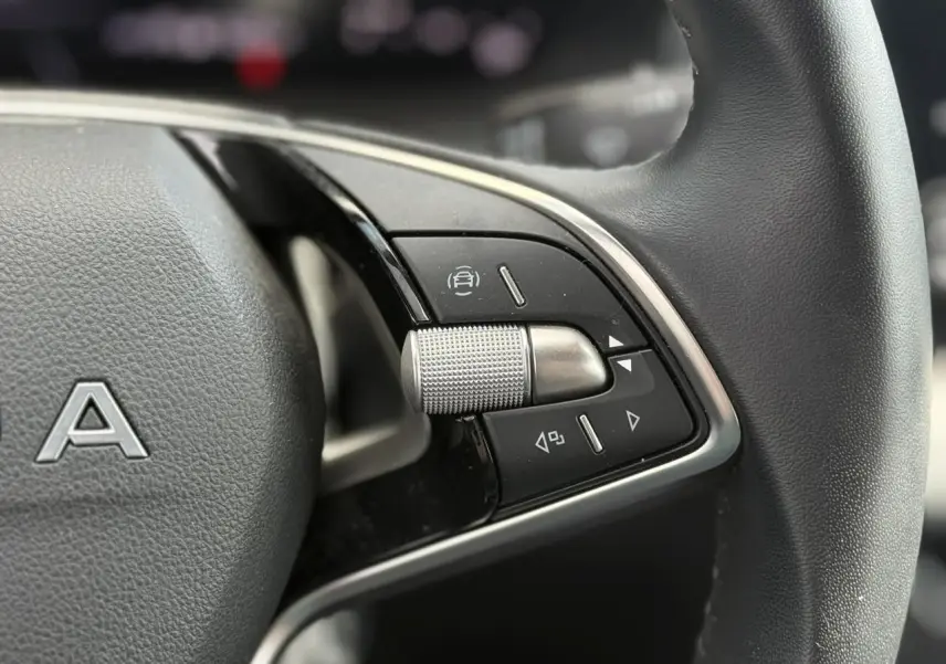 Gros plan sur les commandes multifonctions côté droit du volant en cuir de la Skoda Scala gris graphite.