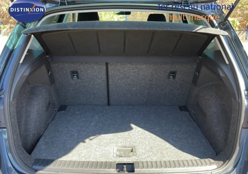 Coffre ouvert vu de l'arrière d'un SEAT Arona gris magnetic metal avec toit noir, montrant l'espace de chargement vide.