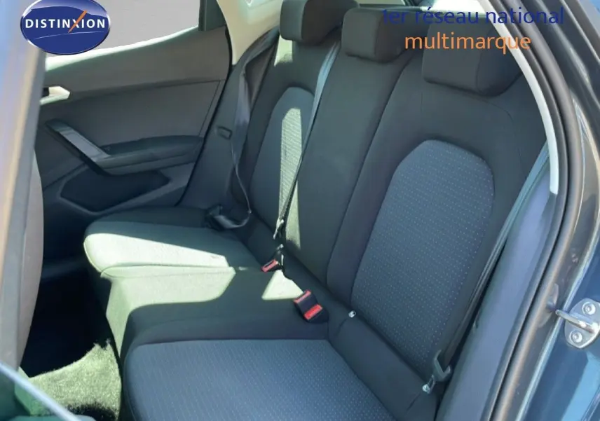 Vue intérieure arrière côté droit montrant les sièges arrière en tissu gris foncé avec motifs discrets sur un SEAT Arona 2025.