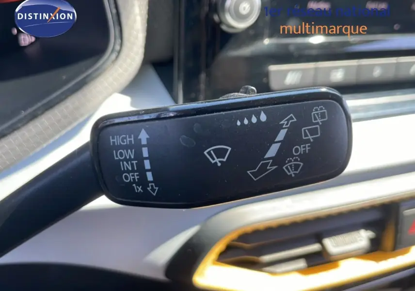 Gros plan sur la commande des essuie-glaces dans l’habitacle gris et noir du SEAT Arona 2025.