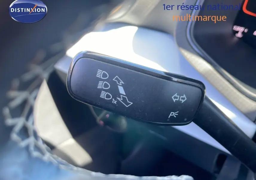 Gros plan sur la commande de clignotants et feux du SEAT Arona 2025, intérieur gris et noir partiellement visible.