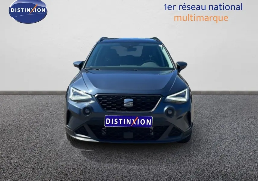 Vue frontale d'un SEAT Arona 2025 gris Magnetic Metal avec toit noir, phares LED allumés sur fond neutre.