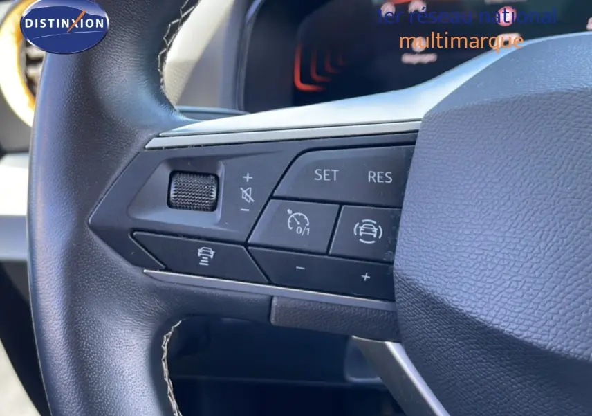 Gros plan sur les commandes au volant en cuir noir du SEAT Arona 2025, mettant en valeur les boutons de régulateur de vitesse.