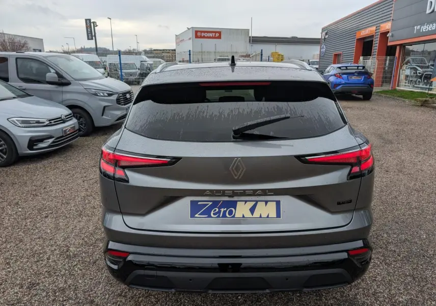 Vue arrière d'un Renault Austral gris avec feux LED distinctifs et hayon motorisé sur parking extérieur.