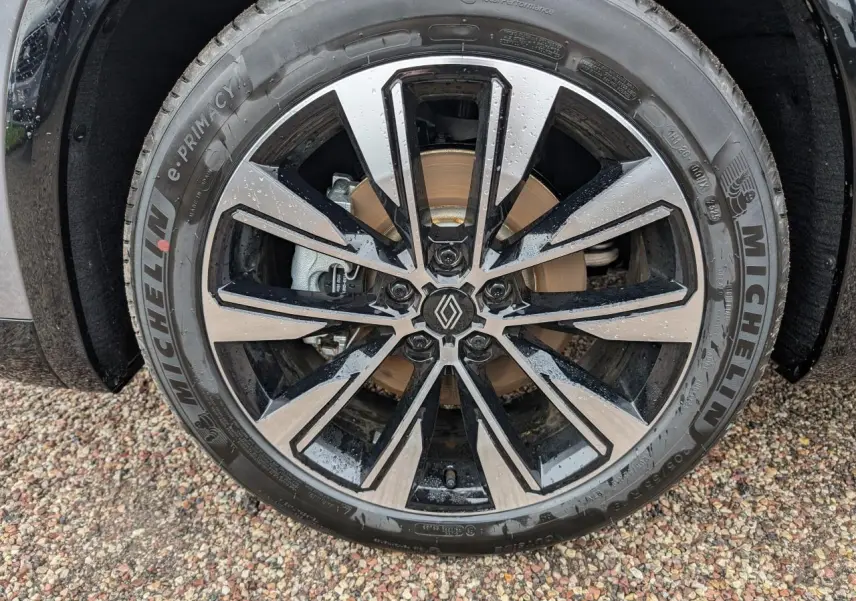 Gros plan sur la jante alliage diamantée noir brillant du Renault Austral gris, avec pneu Michelin visible.