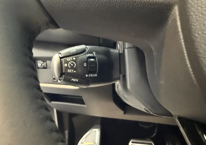 Gros plan sur la commande de régulateur de vitesse derrière le volant du Citroën C5 Aircross gris Artense 2022.