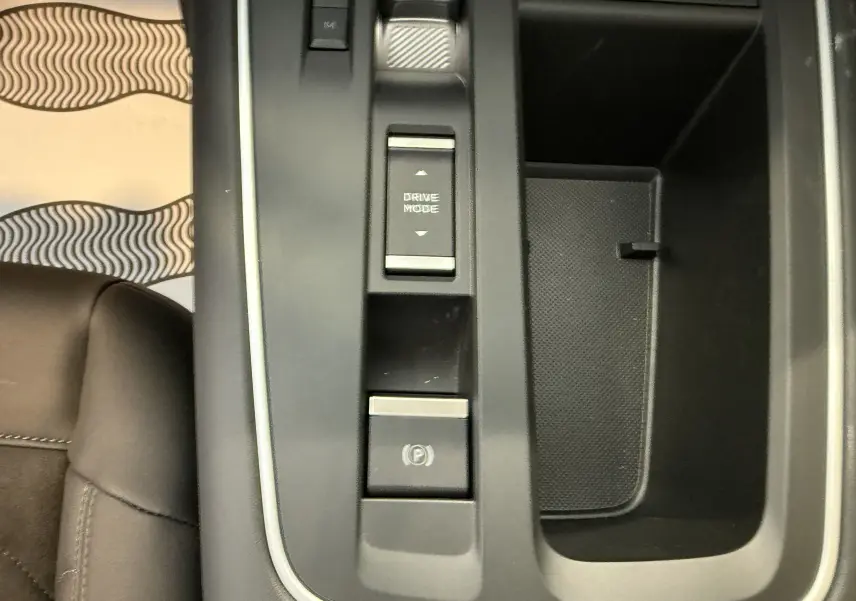 Gros plan sur la console centrale noire du Citroën C5 Aircross 2022, avec boutons Drive Mode et frein à main électronique.