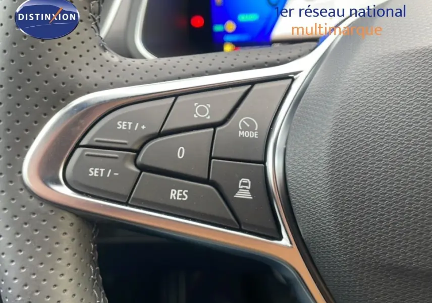 Gros plan sur les commandes au volant en cuir perforé noir du Renault Symbioz 2025, boutons de régulateur de vitesse visibles.