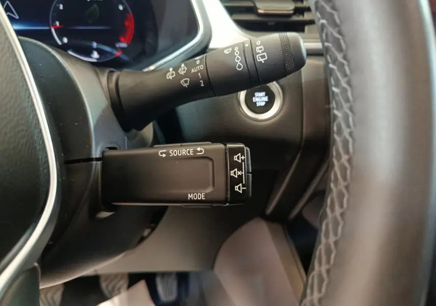 Gros plan sur la commande multifonctions et le bouton start/stop du tableau de bord du Renault Captur gris foncé 2024.