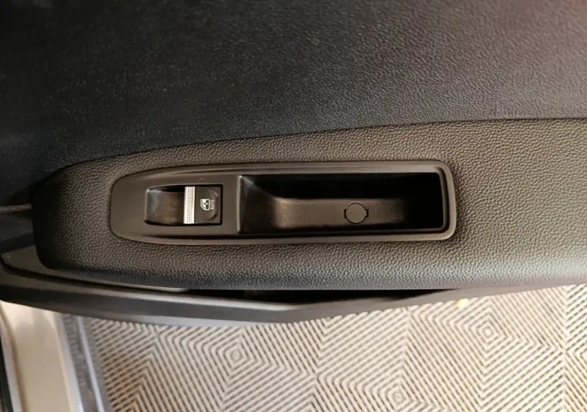 Gros plan sur la commande de lève-vitre côté gauche de la porte d’une Renault Captur gris foncé 2024.