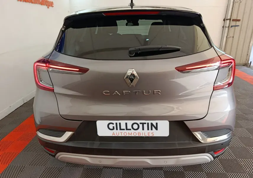 Vue arrière d'un Renault Captur gris foncé 2024 avec feux LED allumés dans un garage.