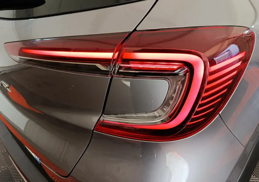Gros plan sur le feu arrière droit allumé du Renault Captur 2024 gris foncé, soulignant son design moderne et lumineux.