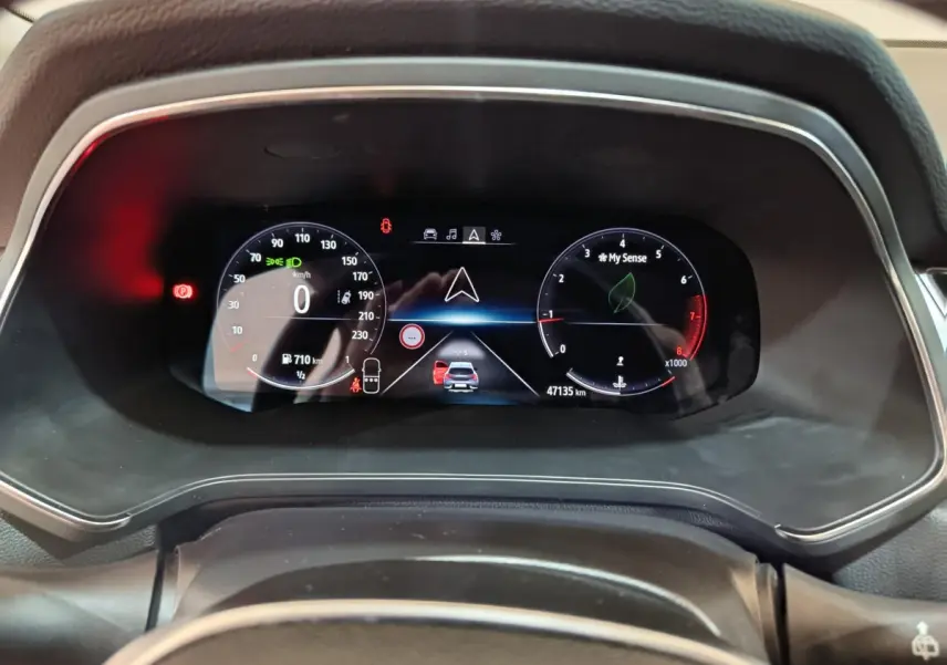 Vue rapprochée du combiné d'instruments numérique du Renault Captur gris foncé, affichant la navigation et les compteurs.