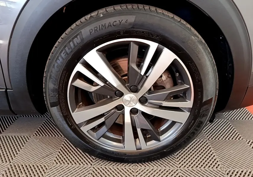 Gros plan sur la roue avant droite du Peugeot 3008 gris foncé avec jante alliage et pneu Michelin Primacy 4.