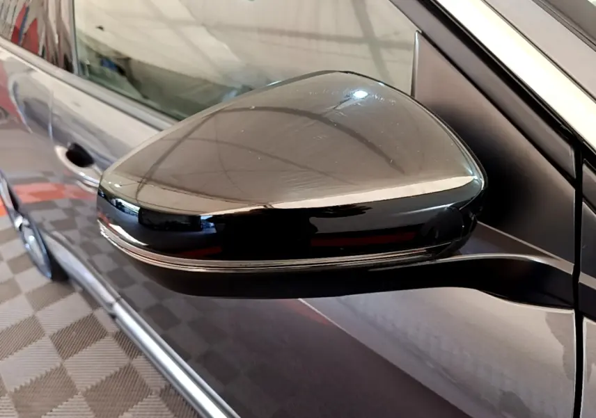 Rétroviseur droit noir brillant du Peugeot 3008 gris foncé, vue rapprochée sur la portière côté droit.