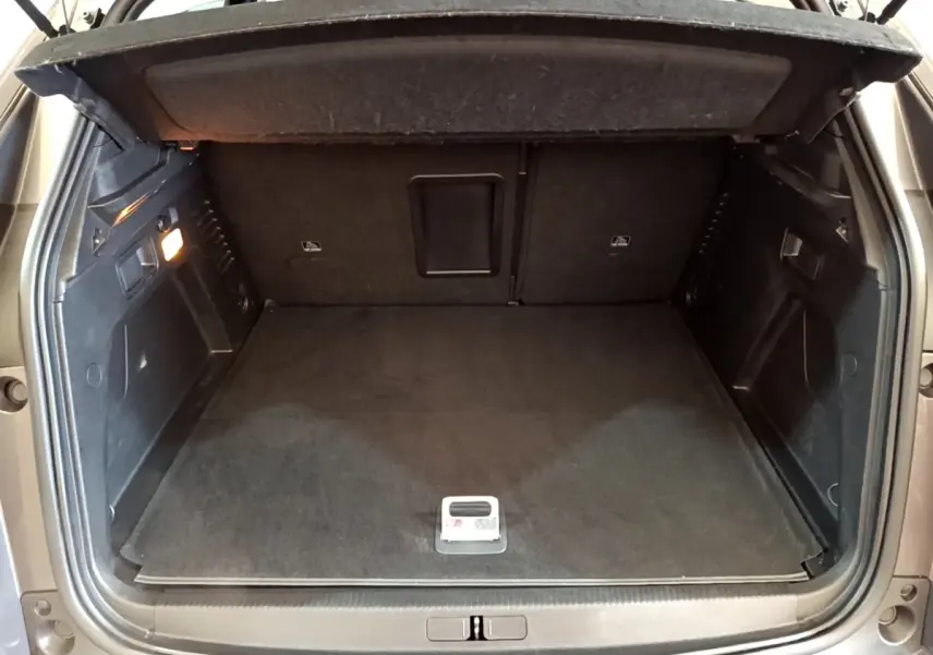 Coffre ouvert du Peugeot 3008 gris foncé, vue arrière, espace de chargement propre et bien éclairé.