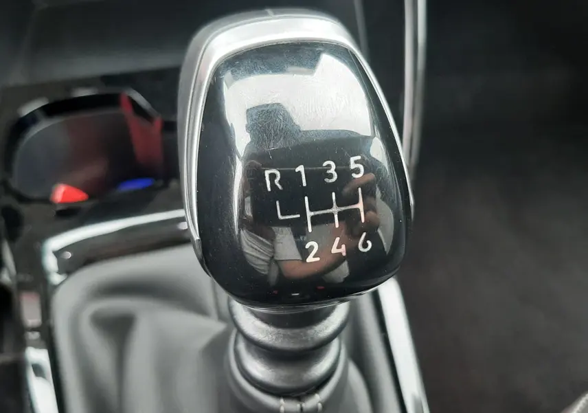 Le levier de vitesses manuel noir brillant de la Citroën C3 1.2 Turbo 100ch Max, avec marquages blancs visibles.