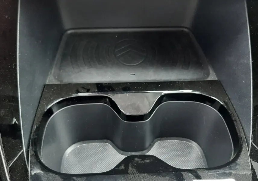 Vue rapprochée de la console centrale noire de la Citroën C3 2025, avec porte-gobelets et surface antidérapante au logo Citroën.