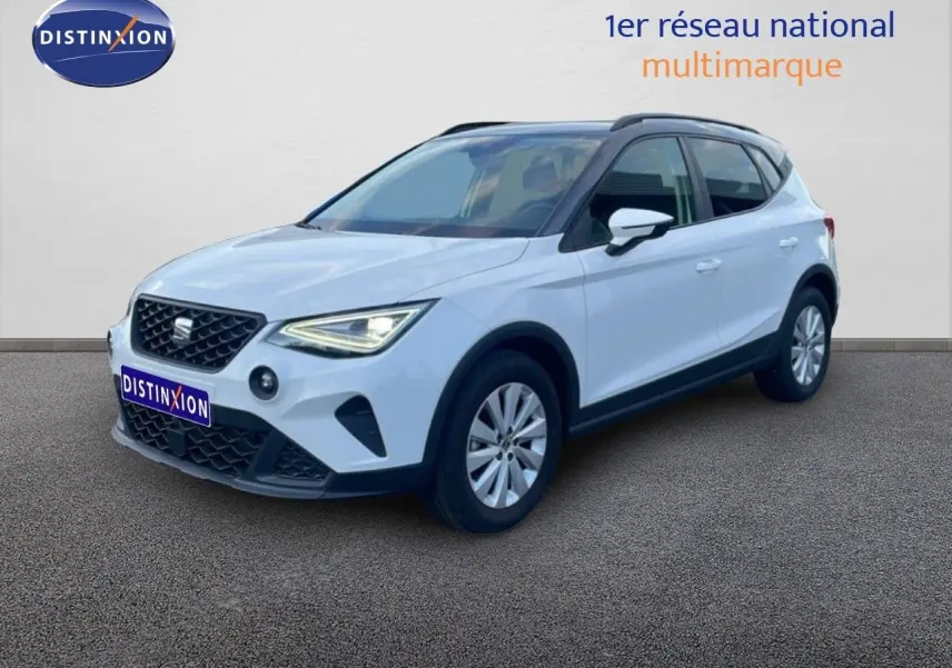 SEAT Arona blanc avec toit gris, vue 3/4 avant droit, mettant en valeur ses phares LED et sa calandre distinctive.