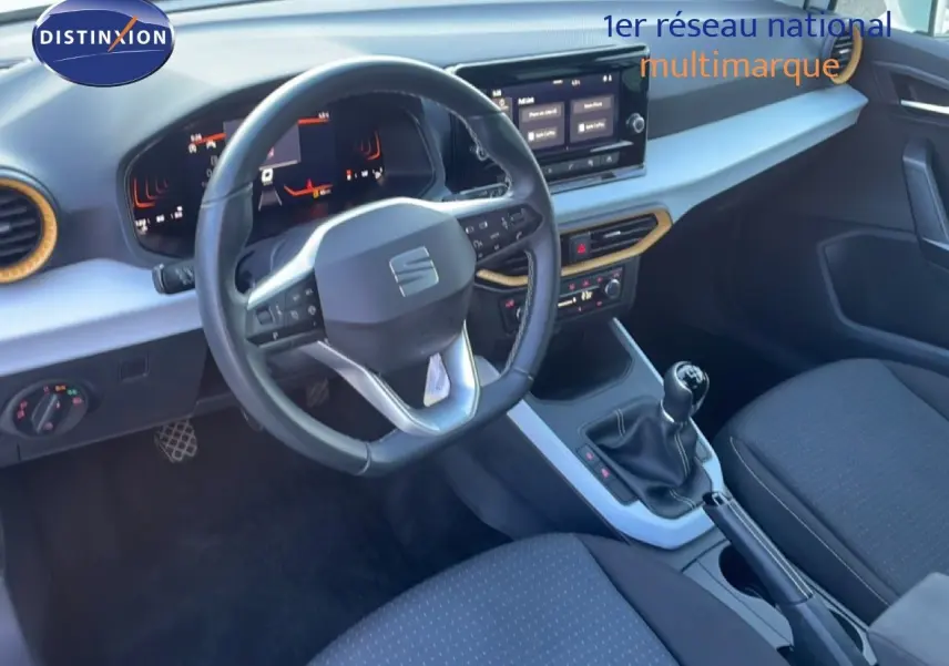 Intérieur du SEAT Arona 2025 vu côté conducteur, volant cuir multifonction, tableau de bord numérique et boîte manuelle.