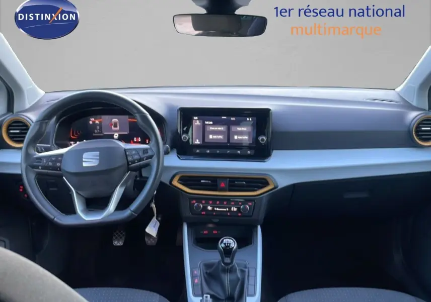 Intérieur avant du SEAT Arona blanc toit gris 2025, tableau de bord moderne avec écran tactile et volant multifonction.