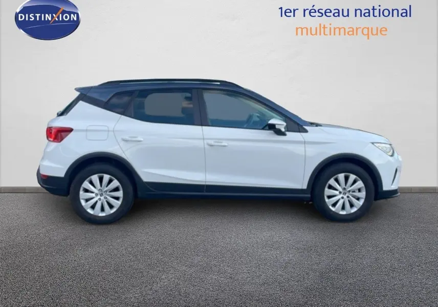 Vue de profil côté gauche d'un SEAT Arona blanc avec toit gris, roues alliage et détails noirs sur les bas de caisse.