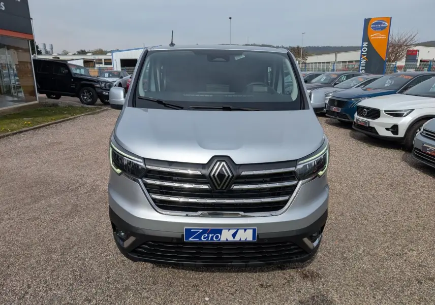 Vue de face du Renault Trafic Fourgon gris avec calandre chromée et feux LED en forme de C.