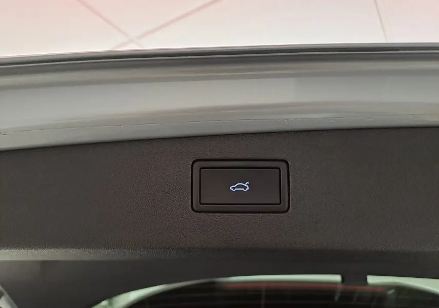 Bouton de hayon électrique sur le bord intérieur du coffre du Volkswagen Tiguan 2.0 TDI 150 DSG7 R-LINE argent Dolomite.