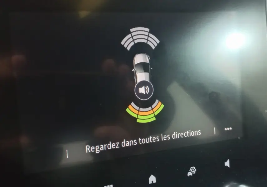 Affichage tactile intérieur montrant vue aérienne et capteurs de proximité d’une Renault Mégane gris foncé.