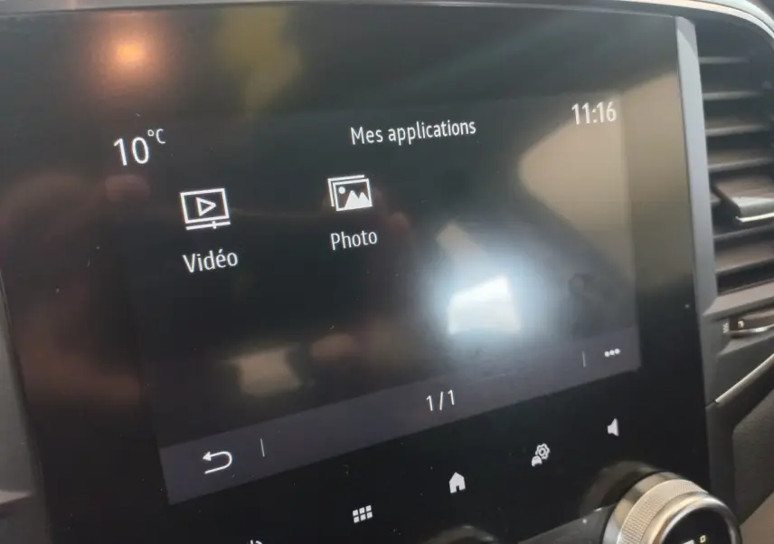 Écran tactile central affichant les applications vidéo et photo dans l’habitacle d’une Renault Mégane Business gris foncé.
