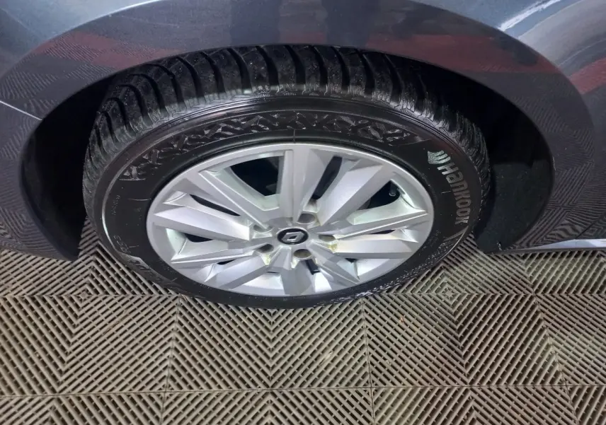 Gros plan sur la roue arrière droite grise foncée d'une Renault Mégane Business TCe 115 FAP avec jante argentée et pneu Hankook.
