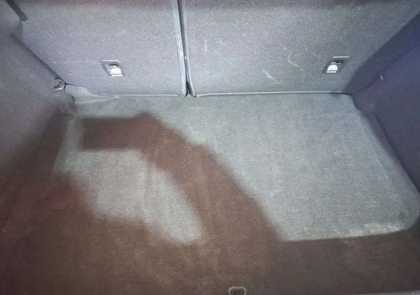 Coffre spacieux gris foncé de la Renault Mégane Business TCe 115 vu de dessus, avec banquette arrière rabattable.