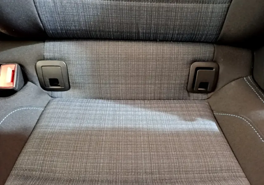 Gros plan sur la banquette arrière grise à motifs de la Volkswagen Passat hybride rechargeable, avec attaches ISOFIX visibles.