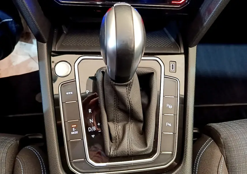 Le levier de vitesse automatique noir de la Volkswagen Passat hybride rechargeable vu de dessus, entouré de boutons de commande.