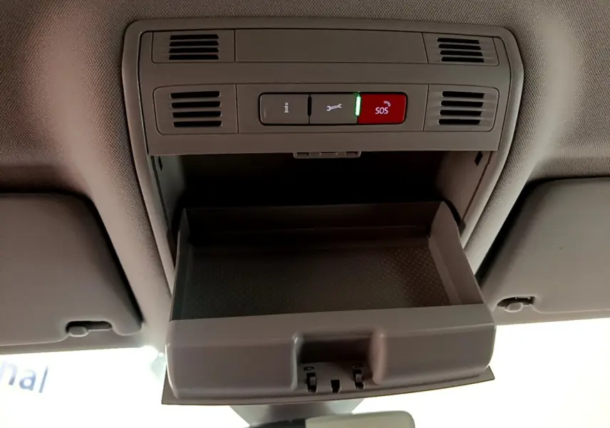 Vue intérieure en plongée du compartiment de rangement ouvert au plafond d'une Volkswagen Passat blanche hybride rechargeable.