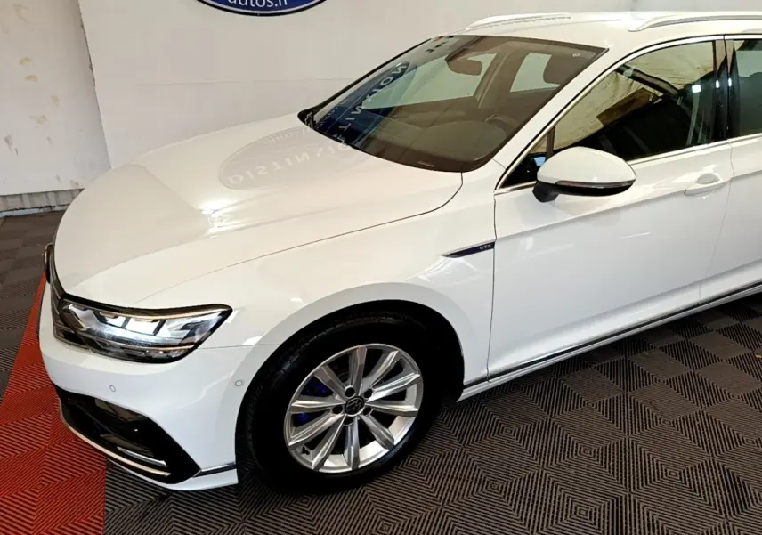 Vue 3/4 avant droite d'une Volkswagen Passat blanche hybride rechargeable avec jantes alliage et badge GTE sur aile.