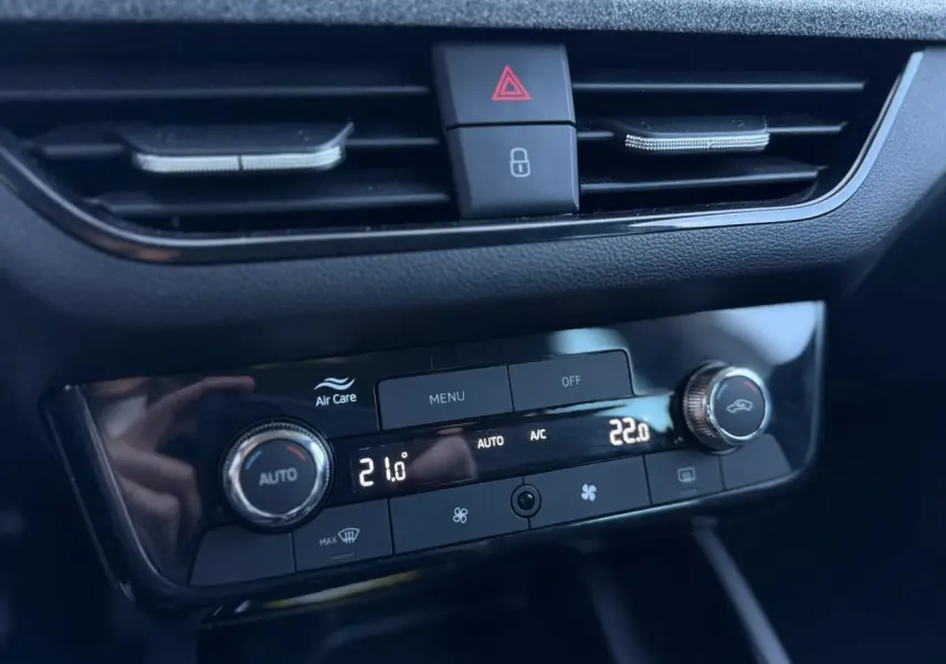 Gros plan sur la console centrale de la Skoda Scala TSI 116, affichant la climatisation automatique bi-zone avec réglages numériques.