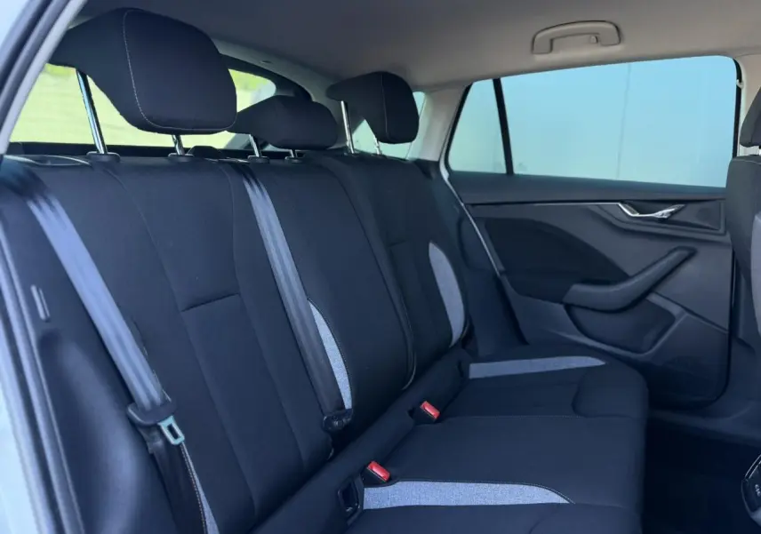 Vue intérieure côté gauche des sièges arrière noirs avec inserts gris d'une Skoda Scala TSI 116 Sélection 2025.