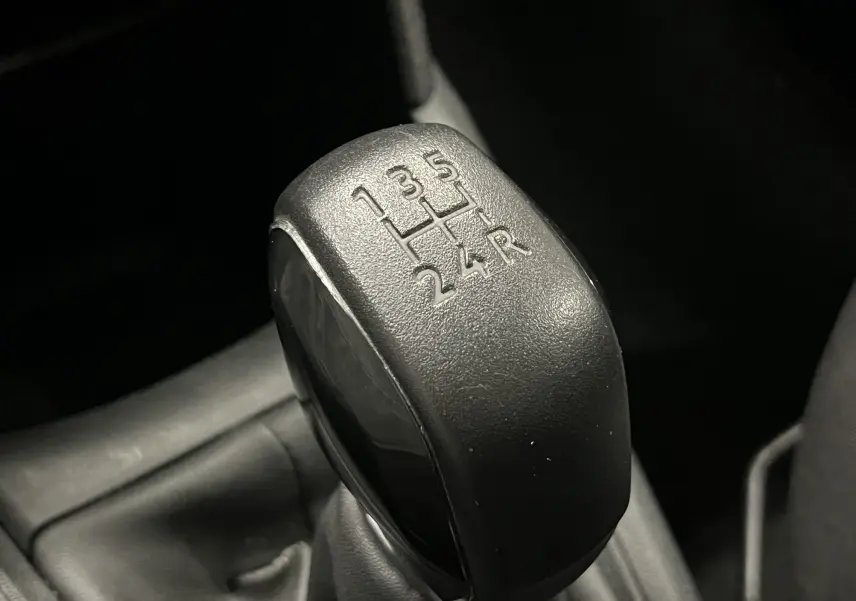 Le levier de vitesses manuel noir en gros plan de la Peugeot 208 1.6 E-HDI Active 2014.