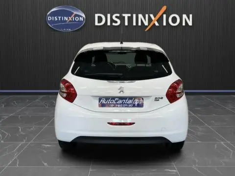 Vue arrière d’une Peugeot 208 blanche 2014, compacte avec feux rouges et hayon fermé dans un showroom.