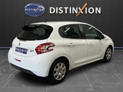 Peugeot 208 blanche vue en 3/4 arrière droit, avec hayon noir et cinq portes dans un showroom.