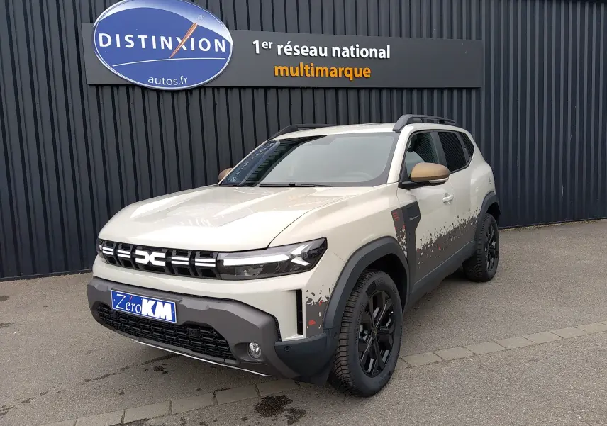 Dacia Duster Hybrid-G 150 ch en Sandstone, vue 3/4 avant droit avec décor pixelisé noir et rouge sur les flancs.