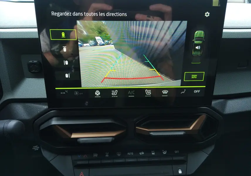 Écran central du Dacia Duster 2026 montrant la caméra de recul avec vue arrière et interface de contrôle climatisation.
