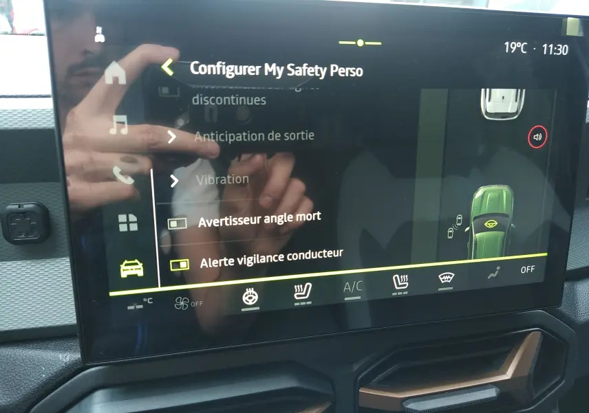 Écran tactile central du Dacia Duster Hybrid-G 150 ch Spirit of Sand, affichant les options de sécurité et climatisation.