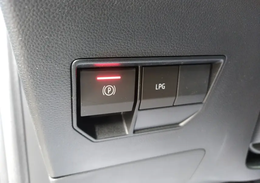Gros plan sur les boutons du frein à main électronique et mode GPL dans l'habitacle du Dacia Duster Hybrid-G 150 ch.